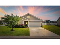 Charming single-Gathering home with well-manicured lawn, two car garage, and grey siding at 924 Sorano St., Myrtle Beach, SC 29579