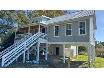 Lovely home exterior boasts a metal roof, large staircase, and gray siding at Tbd Park St., Georgetown, SC 29440