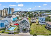 Stunning multi-story beach house with balconies, and a swimming pool, nestled in a vibrant coastal community at 113-A Vista Dr., Garden City Beach, SC 29576