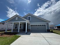Charming single-story home with a two-car garage, covered porch, and blue siding at 1241 Beeblossom Dr., North Myrtle Beach, SC 29582