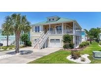 Charming two-story home features a metal roof, upper porch, well-maintained lawn, and a palm tree at 128 Lake Pointe Dr., Murrells Inlet, SC 29576