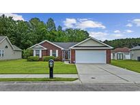Charming single-story brick home featuring a well-manicured lawn and a two-car garage at 208 Hamilton Way, Conway, SC 29526