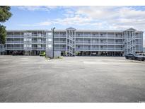 Condominium building exterior featuring a raised structure, parking, and stairwells to access units at 310 Marsh Pl. # 108, Murrells Inlet, SC 29576