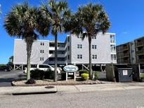 Exterior view of WindSong building featuring beachy landscapes and palm trees at 4303 South Ocean Blvd. # 303, North Myrtle Beach, SC 29582