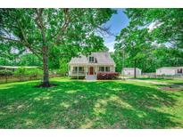 Charming traditional home with a inviting front porch and well-manicured lawn surrounded by mature trees at 5113 Pee Dee Ln., Murrells Inlet, SC 29576