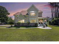 Charming home featuring a rounded porch, lush lawn, and well-maintained landscaping at 5460 Huntington Marsh Rd., Murrells Inlet, SC 29576