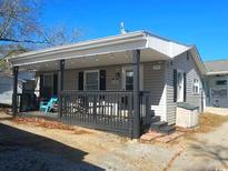Charming single-story home with a covered porch, dark shutters, and gray siding at 6001 S Kings Hwy., Myrtle Beach, SC 29575