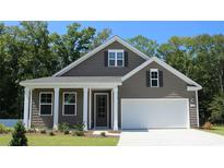 Charming single-Gathering home featuring a two-car garage, neutral color siding and a covered front porch at 886 Ireland Dr., Longs, SC 29568