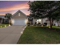 Charming single-story home with a well-manicured lawn, complemented by a large driveway and elegant exterior lighting at 15 Saltwind Loop, Murrells Inlet, SC 29576