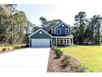 Charming two-story home with blue siding, white trim, and a spacious two-car garage at 155 Mckenzie Circle, Pawleys Island, SC 29585