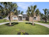 Charming brick home featuring a circular driveway, manicured lawn and accentuated by two mature palm trees at 2981 Victor Rd., Longs, SC 29568