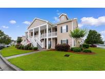 Inviting exterior of home with a welcoming porch, lush landscaping, and classic architectural details at 411 Mahogany Dr. # 101, Murrells Inlet, SC 29576