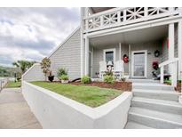 Charming front porch with white chairs, flowers, and lush landscaping provides an inviting entrance to this lovely home at 4396 Baldwin Ave. # 1, Little River, SC 29566