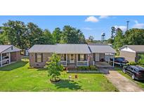 Charming brick home featuring a well-manicured lawn, covered parking, and a welcoming front porch at 517 Cardinal Dr., Conway, SC 29526
