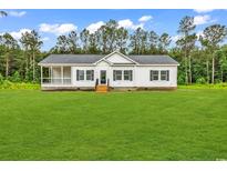 Charming single-story home with a covered porch and a large, well-manicured lawn at 565 Kent Rd., Georgetown, SC 29440