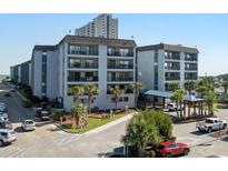 Beautiful condo building with ocean view, mature landscaping, and ample parking at 5905 S Kings Hwy. # 242B, Myrtle Beach, SC 29575