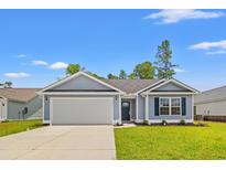 Charming one-story home with a well-manicured lawn, attached garage, and inviting entrance at 600 Woodside Dr., Conway, SC 29526