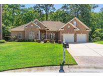 Beautiful brick home featuring a well-manicured lawn and a two-car garage and driveway, offering excellent curb appeal at 6572 Wellington Dr., Murrells Inlet, SC 29576