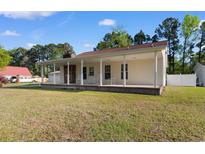 Charming single-story home featuring a inviting porch and a stone chimney at 6593 Sunshine St. Nw, Ocean Isle Beach, NC 28469