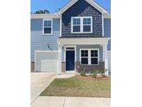 Charming two-story home with blue siding, a garage, and a well-manicured lawn at 786 Nw Palm Frond Way # 51, Calabash, NC 28467