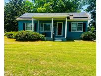 Charming one-story home with front porch, lush lawn, and solar panels on the roof at 8 Raymond St., Andrews, SC 29510