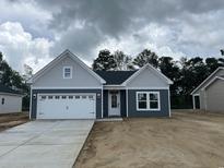 Charming single-story home with gray siding, white garage door, and a well-manicured lawn at 122 Westfield Circle, Conway, SC 29526