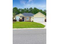 Charming single-story home featuring a well-manicured lawn, attached garage, and inviting front entrance at 137 Maiden Ln., Myrtle Beach, SC 29588