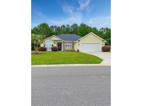 Charming single-story home with manicured lawn, a lovely palm tree and an attached two car garage at 137 Maiden Ln., Myrtle Beach, SC 29588