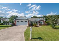 Charming brick home with a well-manicured lawn, mature landscaping, and a spacious two-car garage at 1388 Gailard Dr., Conway, SC 29526