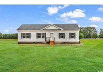Charming single-story home with a well-maintained lawn and classic design against a bright sky at 1529 Bucksport Rd., Conway, SC 29527