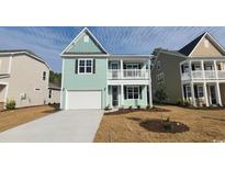 Charming two-story home with a welcoming front porch, a manicured lawn, and an attached garage at 153 Stride Ct., Myrtle Beach, SC 29588