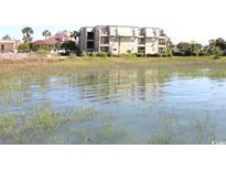 View of multi-story condo building from the water, reflecting in the foreground at 1582 South Waccamaw Dr. # 56, Garden City Beach, SC 29576