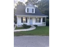 Charming home with a cozy front porch, black shutters, and a well-manicured lawn at 1676 Citadel Ln., Myrtle Beach, SC 29577