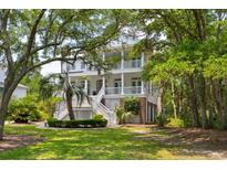 Two-story home boasts dual porches, lush landscaping, and a charming stairway entrance framed by mature trees at 214 Sea Island Dr., Georgetown, SC 29440