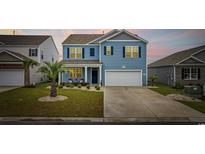 Charming two-story home with blue siding, dark shutters, well-manicured lawn and a two car garage at 3573 Bells Lake Circle, Longs, SC 29568