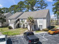 Well-maintained condo building with palm trees and ample parking on a sunny day at 4486 Little River Inn Ln. # 2103, Little River, SC 29566