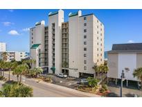 An exterior shot of the multi-story Beach Club III building, showcasing its architecture, surrounding landscaping, and parking area at 4505 S Ocean Blvd. # 5D, North Myrtle Beach, SC 29582