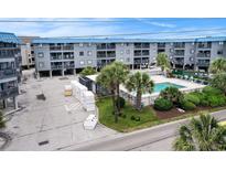 Coastal condominium complex featuring a refreshing swimming pool surrounded by lush landscaping at 6000 N Ocean Blvd. # 329, North Myrtle Beach, SC 29582