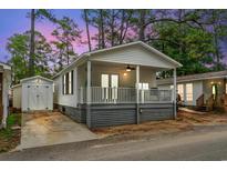 Charming home featuring a welcoming front porch and convenient storage shed at 6001 - 1498 S Kings Hwy., Myrtle Beach, SC 29575