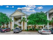 Attractive condo exterior with stacked balconies, mature trees, and ample parking at 601 Hillside Dr. N # 3704, North Myrtle Beach, SC 29582