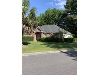 Charming brick home features lush landscaping, mature trees, and a well-maintained lawn at 700 Two Rivers Ct., Myrtle Beach, SC 29579
