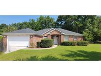 Charming brick home with manicured lawn, mature trees, and attached garage at 700 Two Rivers Ct., Myrtle Beach, SC 29579