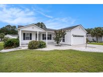 Charming single-story home with white siding, manicured lawn, and attached two-car garage at 1001 Greencrest Ct., Conway, SC 29526