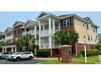 Beautiful condo building with multiple stories and ample parking surrounded by lush landscaping at 1029 Ray Costin Way # Villa 909, Murrells Inlet, SC 29576