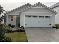 Charming home exterior features a two-car garage, manicured lawn, and traditional architectural details at 1064 Oak Meadow Dr., Conway, SC 29526