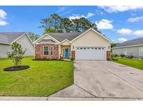 Charming single-story home featuring a manicured lawn, brick accents, and a two-car garage at 135 Maggie Way, Myrtle Beach, SC 29588