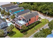 Bright coral beach house with private pool and multiple balconies overlooking lush tropical landscaping at 1617 N Dogwood Dr. N, Surfside Beach, SC 29575