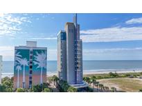 Coastal condo building featuring colorful design, landscaping, and ocean views on sunny day at 1708 N Ocean Blvd. # 101, Myrtle Beach, SC 29577
