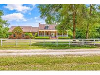 Charming brick home featuring a welcoming front porch and a manicured lawn with a white fence at 1961 Bright Rd., Little River, SC 29566