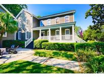 Charming two-story home featuring a covered porch, manicured landscaping, and a well-maintained lawn at 203 Broad St., Georgetown, SC 29440